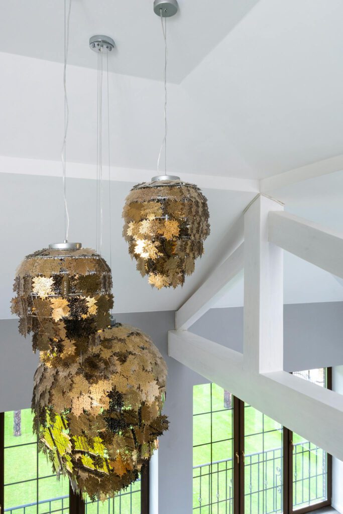 Interior of modern apartment with big gold pendant lamp hanging on ceiling with geometrical construction